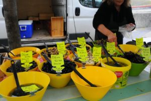 Woman buying olives at the market place in Lyon, France