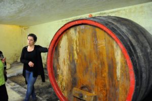 Véronique Cunty of Domaine de Font-Sane standing next to a large wine barrel.