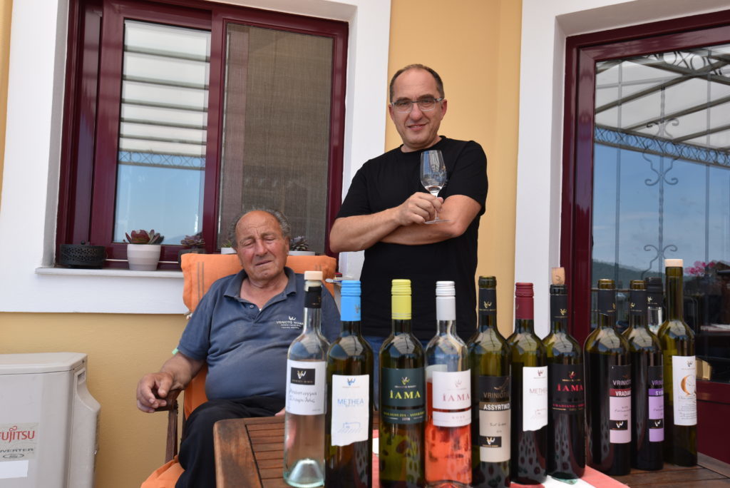 Konstantinos Vriniotis and his father standing with the line up of wines from Vriniotis winery