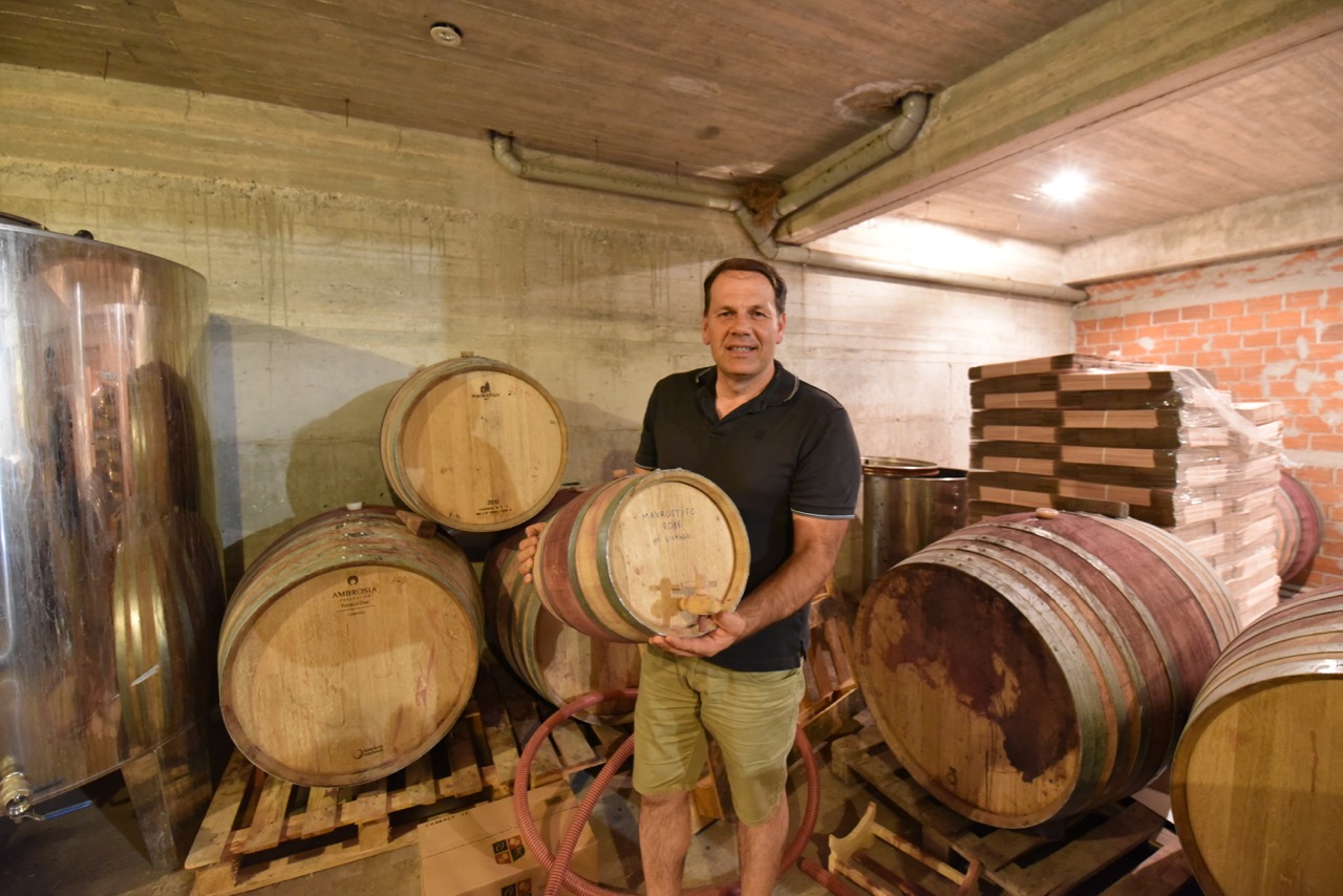 Yannis Papargyriou holding a barrel of wine