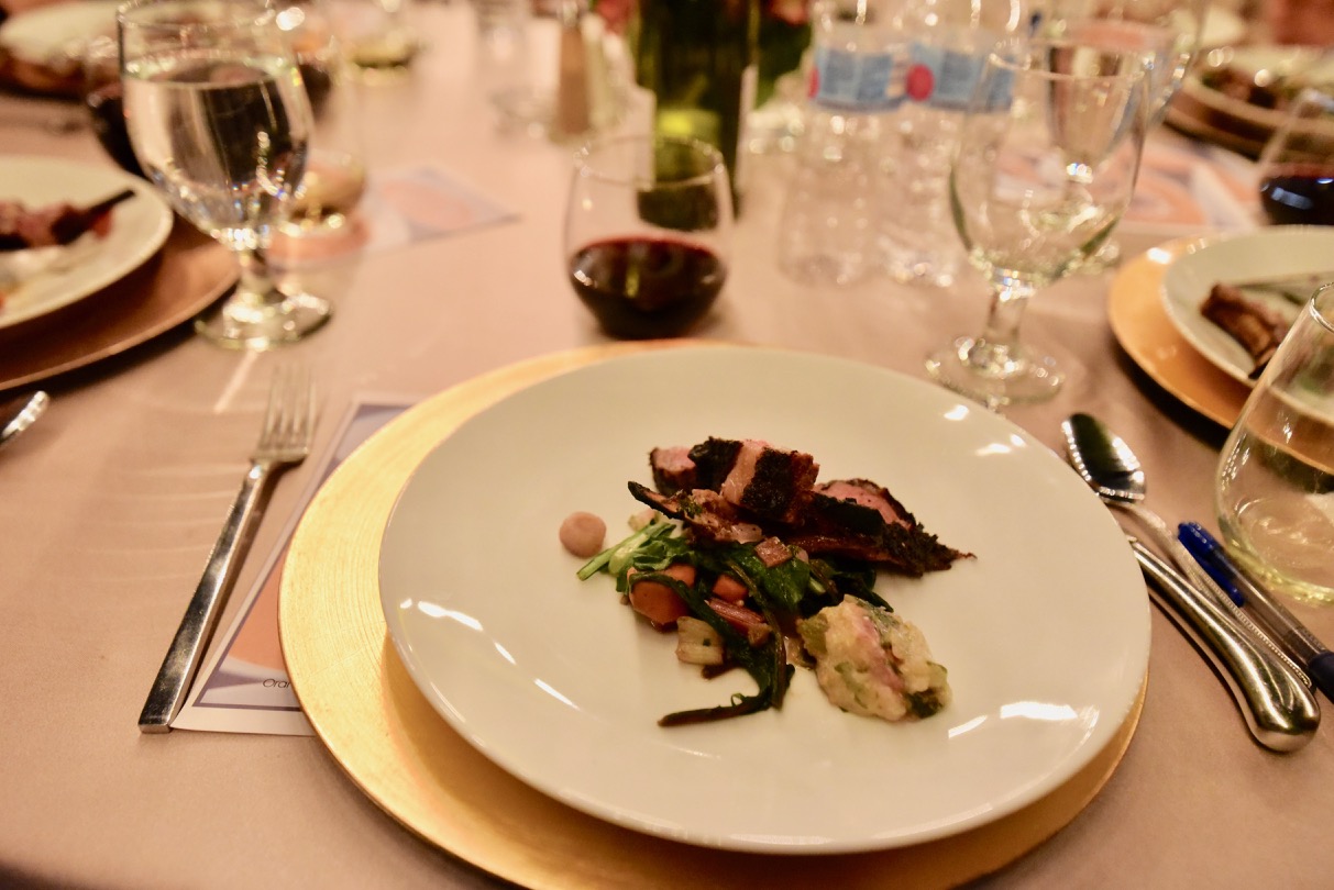 Plate of grilled lamb with mustard greens and rainbow chard.