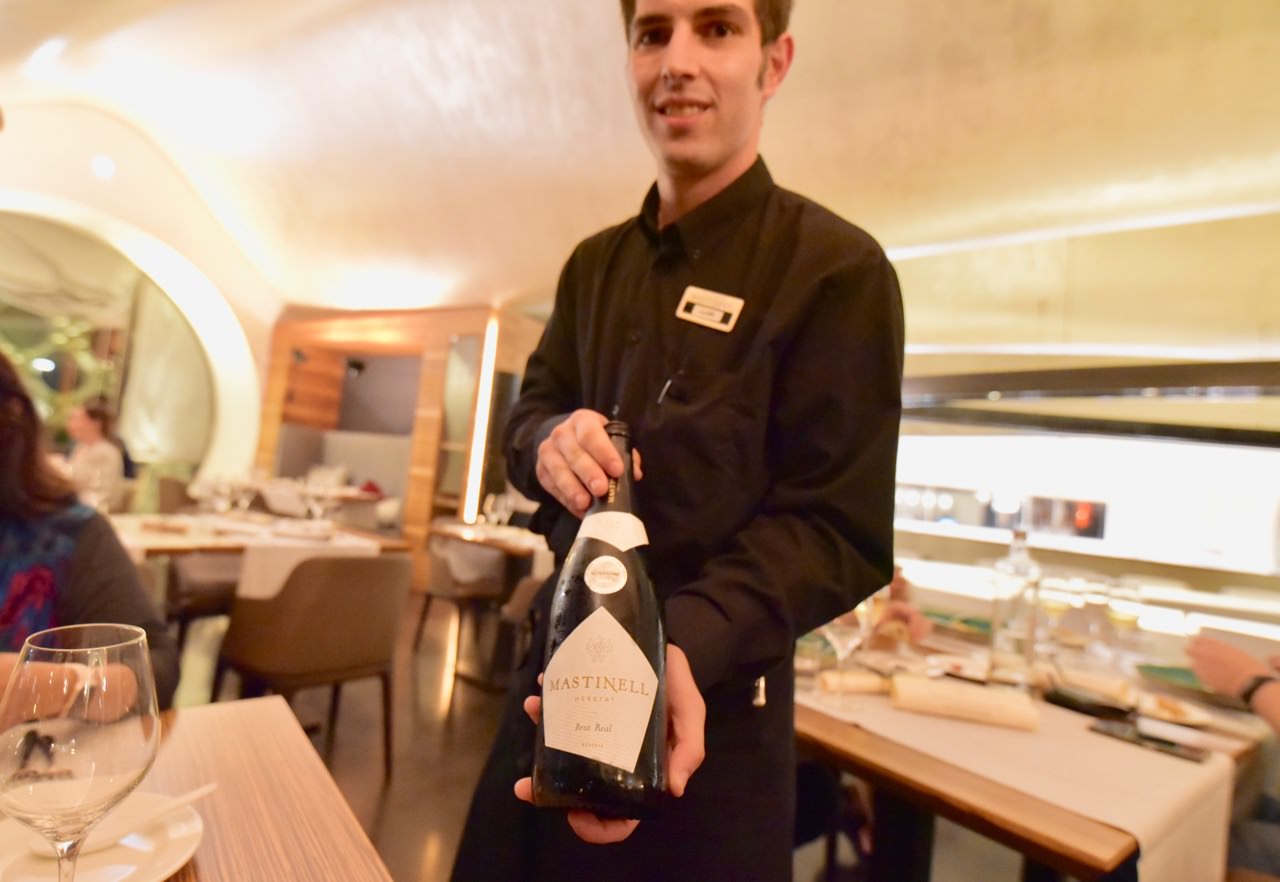 Waiter displaying a bottle Mastinell Cava at En Rima Restaurant.