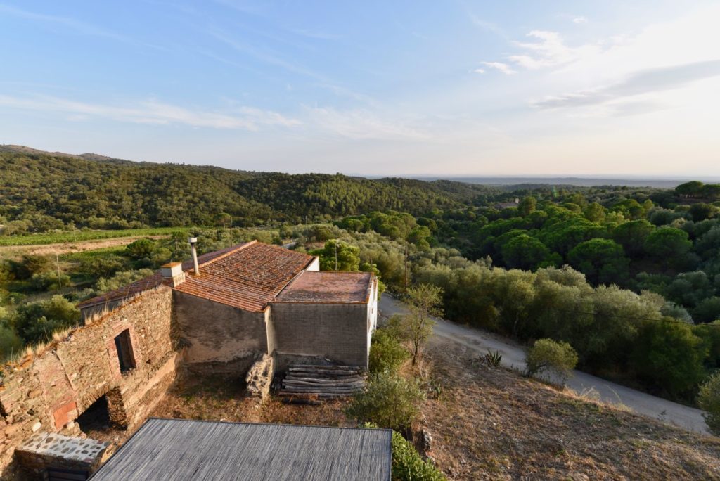 View of an old farm house with mountains in the distance.