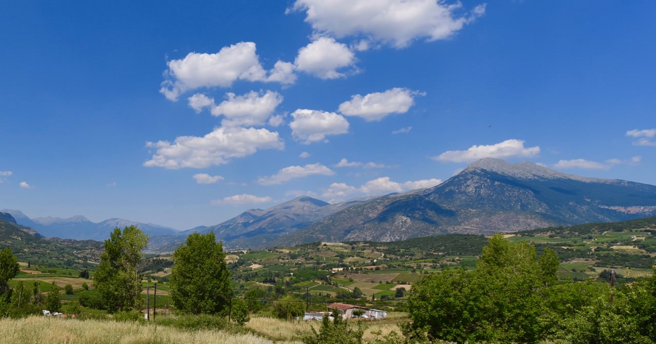 Mountains in the distance with blue skies and clouds.