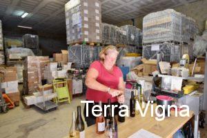 A lady opening bottles of wines on a table.