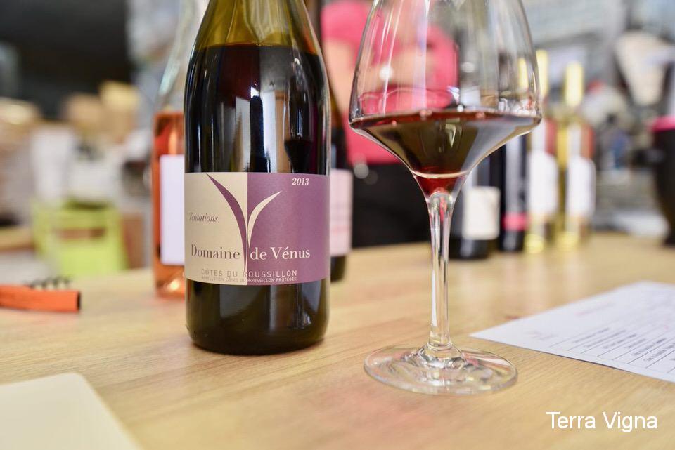 Bottle of wine with some red wine in a glass.