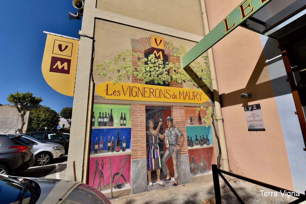 A mural on a wall of a man and a woman by a doorway with wine.