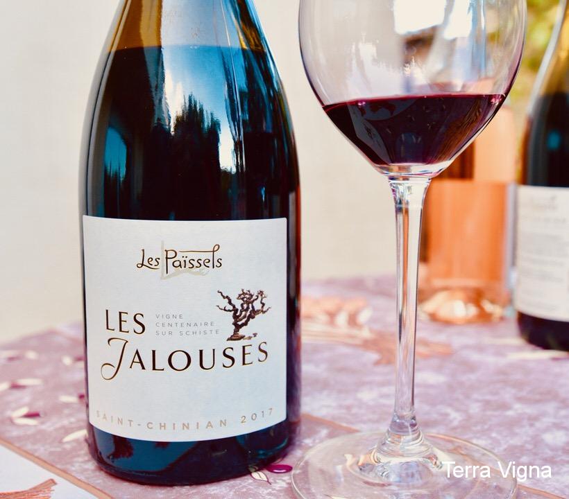bottle of les jalousies wine with a glass of wine next to it.