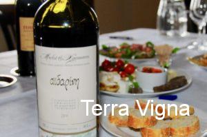 Bottle of wine next to plates of food.