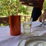 A metal carafe with a glass with wine.