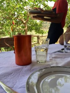 A metal carafe with a glass with wine.