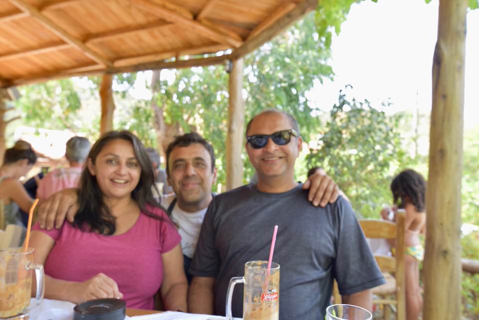 Two men and a woman smiles at the camera.