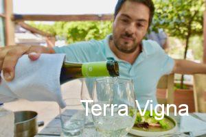 A man pouring a bottle of white wine into a glass.