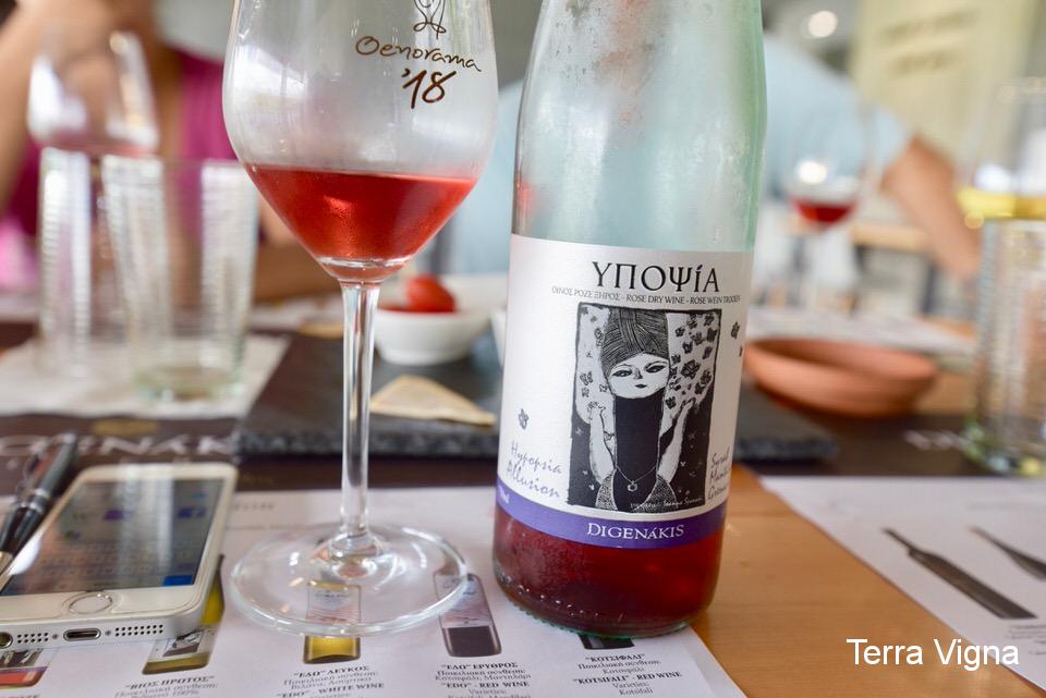 A bottle of rosé wine next to a glass of rosé wine.